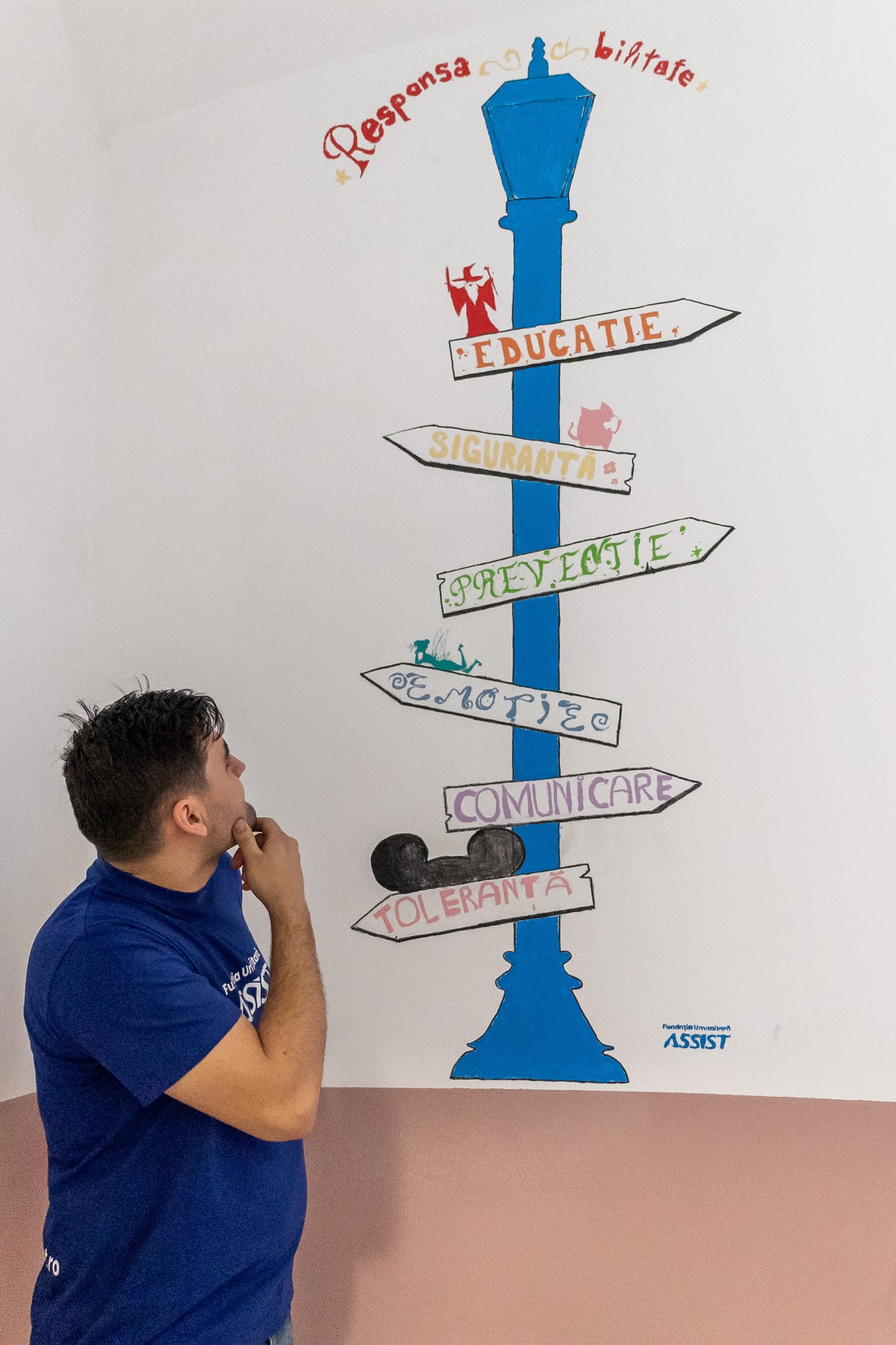 The ASSIST Humanitarian Foundation volunteer admiring the fresh painting